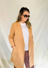 Chaqueta larga color camel de paño con solapas, doble botonadura y bolsillos laterales.