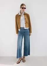 Jeans de corte wide leg y tiro medio, en color azul clásico, con diseño de perneras anchas y terminación deshilachada en el bajo.