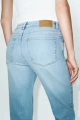 Jeans de tiro alto con corte mini flare y largo tobillero. Presentan diseño de cinco bolsillos, pernera estrecha con acabado evasé y cierre frontal con cremallera y botón.