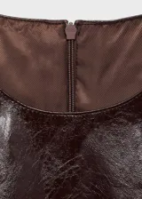 Vestido corto de efecto piel con diseño recto y cuello redondo. Presenta un corte sin mangas y cierre de cremallera invisible en la parte posterior.