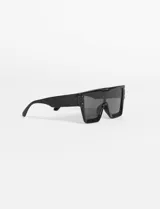 Lentes de sol rectangulares oversized de estilo tecno, con marco negro y cristales oscuros. Ofrecen filtro de protección UV 400 que bloquea rayos UVA y UVB.