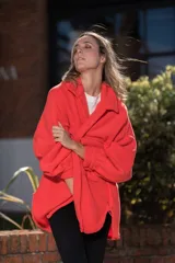 Camisa roja de polar, corte oversize, con cuello camisero, cierre frontal con botones a presión, mangas largas con puños abotonados, bolsillos de parche en el pecho y ruedo redondeado.