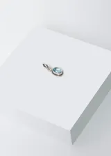 Dije de plata 925 con topacio azul ovalado facetado.