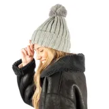 Gorro de lana gris con textura acanalada y pompón en la parte superior.