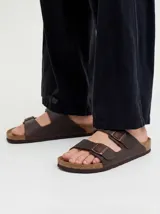Sandalias de dos tiras con hebillas metálicas ajustables, plantilla anatómica y suela de corcho y goma.