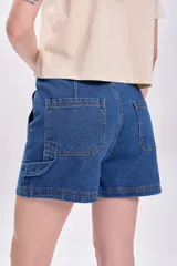 Short de jean en color azul marino, con diseño de tiro medio, bolsillos frontales tipo cargo y cierre con botón metálico.