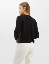 Chaqueta Sioni con frente de cuero sintético y mangas y espalda de tejido de punto. Presenta cuello a la base, cierre frontal con botones a presión y bolsillos delanteros.