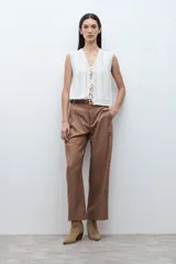 Pantalón de vestir de corte recto y tiro medio, confeccionado en lyocell. Presenta pinzas frontales, bolsillos laterales y cierre con botón y cremallera.