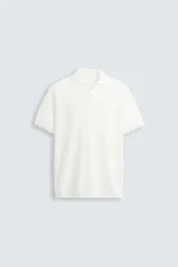 Jersey de punto color verde oliva, de calce relajado (relaxed fit), con cuello solapa y abertura frontal en forma de V. Es de manga corta y presenta acabados en rib en puños y ruedo.