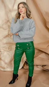 Pantalón chupín de simil cuero color verde con tiro medio y detalle de botones dorados.