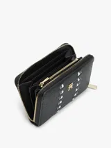 Billetera de mujer Tommy Hilfiger con acabado granulado, cierre de cremallera perimetral y logo TH metálico en el frente. Presenta un diseño con detalle de cinta distintiva tonal y tirador metálico con monograma.