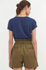 Short de tiro alto color verde militar con bolsillos delanteros y lazo en la cintura.
