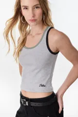 Musculosa de algodón color beige con ribetes naranjas en el cuello y sisas, corte ajustado y diseño acanalado.