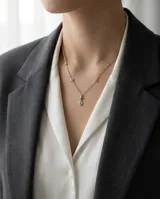 Collar de acero inoxidable con cadena fina y dijes en forma de estrella de cuatro puntas incrustados con circonias.