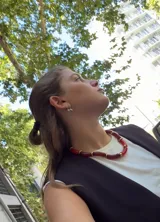 Collar tipo gargantilla compuesto por tubos gruesos de resina color rojo oscuro, separados por cuentas cilíndricas doradas.