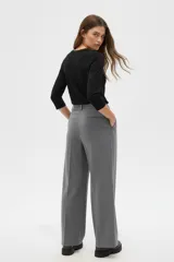 Remera de poliéster color verde oliva, con mangas 3/4, cuello en V con detalle de pliegue central y corte holgado.