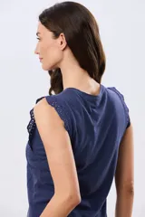 Musculosa de algodón color azul con detalles de broderie calado en los hombros, de cuello redondo y corte clásico.