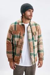 Sobrecamisa de franela con estampado de cuadros en tonos marrones y verdes, cuenta con cierre frontal, cuello clásico y bolsillos con solapa en el pecho.