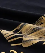 Remera masculina negra de algodón, corte comfort, con cuello redondo y mangas cortas. Presenta una estampa lettering con follaje "Royal Palace" en amarillo en el frente y la espalda.