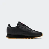 Championes Reebok Classic Leather de diseño minimalista, confeccionados en cuero negro con suela de goma color caramelo. Presentan cierre de cordones, entresuela de EVA y forro textil.