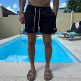 Short de baño negro con cintura elástica y cordón ajustable bicolor. Presenta un parche circular con logo en la parte inferior de la pierna.