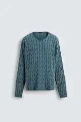 Jersey de algodón de corte relajado, color azul verdoso lavado, con cuello redondo amplio y manga larga. Presenta un tejido de punto con estructura de trenzas verticales.