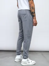 Pantalón de jogging gris de felpa sin friza, con cintura elástica ajustable con cordón y logo de Umbro estampado en blanco en el muslo izquierdo.