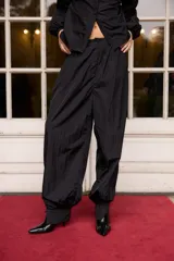 Pantalón de tiro alto confeccionado en nylon, con diseño holgado y puños ajustados en los tobillos.