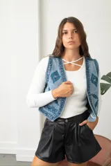 Chaleco de jean con bordados étnicos y detalles de lentejuelas, de corte entallado y cierre frontal.
