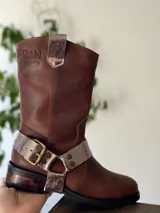 Bota de cuero marrón con estribo desmontable plateado.