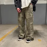 Pantalón de corte super baggy con estampado de piel de serpiente en tonos grises y beige.