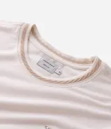 Remera de manga corta y cuello redondo, confeccionada en una mezcla de algodón y poliéster. Presenta un pequeño bordado en el pecho con la letra M.