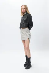 Minifalda gris elastizada con abertura lateral, elástico en la cintura y fibras metálicas.