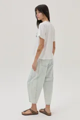 Remera blanca de algodón con cuello redondo y mangas cortas. Estampado en el frente con la palabra "Dolce" en rojo y un diseño floral en negro y verde.