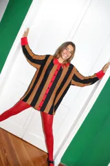 Saco tejido a máquina con rayas verticales negras y marrones, cuello camisero y botones rojos.