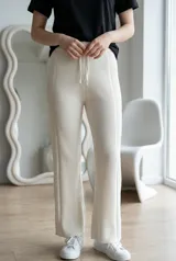 Pantalón tipo palazzo de tejido de punto acanalado en color crudo, con cintura elástica y cordón ajustable.