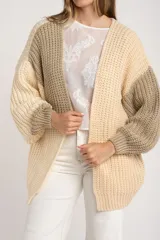 Cardigan de punto grueso con diseño color block en tonos beige, crema y verde oliva. Corte oversize y mangas largas.