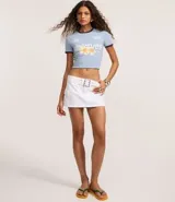 Remera ajustada de algodón color celeste claro con cuello redondo y ribetes en azul marino. Presenta un estampado frontal con la palabra "Maldivas" en blanco y un diseño floral en tonos amarillos y naranjas. Incluye pequeños logos bordados en blanco en el pecho.