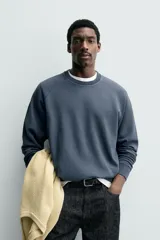 Sudadera regular fit color azul, de cuello redondo, manga larga ranglán y efecto lavado con acabados en rib.