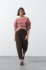 Sweater de punto con diseño jacquard de inspiración nórdica en tonos beige y rojo. Presenta cuello redondo, mangas largas y un calce relajado.