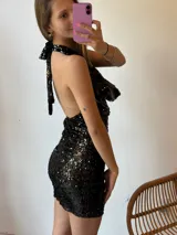 Minivestido negro con lentejuelas, escote halter y espalda descubierta.