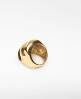 Anillo de metal dorado con diseño orgánico y voluminoso. Presenta logo grabado en el interior.