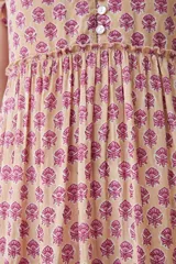 Maxi vestido de corte imperio, color rosa con estampado floral liberty en tonos fucsia. Tiene escote en V, mangas cortas con volados y falda larga con volantes. Cierre frontal con botones.