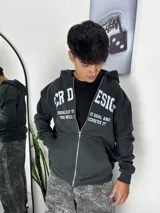 Campera con capucha y cierre frontal, color gris oscuro, con estampado gráfico en blanco en el pecho.