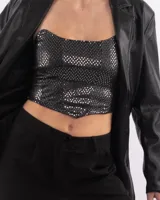 Corset negro con lentejuelas plateadas, sin mangas y con escote recto.