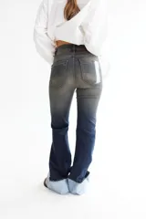 Pantalón de jean azul oscuro, corte oxford con alforza en el delantero y dobladillo en la botamanga.