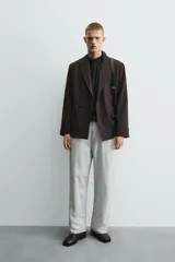 Blazer de corte regular fit confeccionada en tejido con mezcla de lana. Presenta cuello con solapas de pico, cierre frontal de botonadura cruzada, bolsillos con solapa en la cadera y aberturas en la espalda.