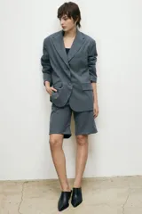 Blazer de corte sastrero en color azul marino con diseño de rayas diplomáticas. Presenta solapas clásicas, cierre frontal con un botón y bolsillos laterales con solapa.