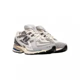 Championes urbanos New Balance modelo 1906, con diseño técnico de estilo retro. Presentan una combinación de malla transpirable y paneles sintéticos en tonos gris, blanco y detalles en azul. Incorporan entresuela con tecnología de amortiguación y suela de goma resistente.