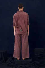 Camisa de gabardina con cuello clásico, cierre frontal de botones y mangas largas con puños vueltos. Presenta un diseño de corte recto y acabado desgastado.